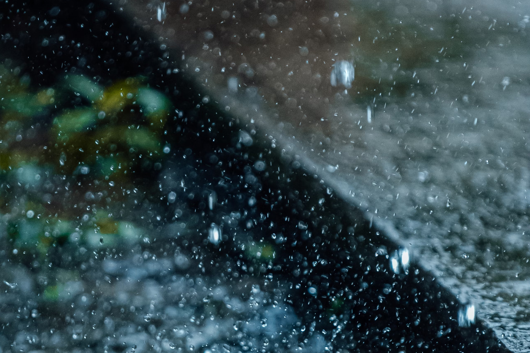 regn på gata/trottoar vid brunn